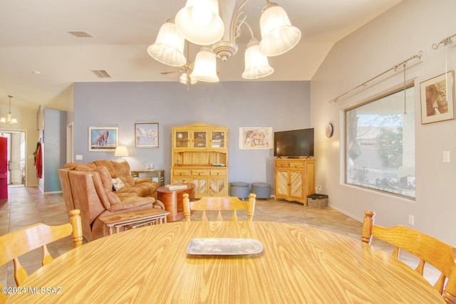 tiled dining space featuring a chandelier and lofted ceiling