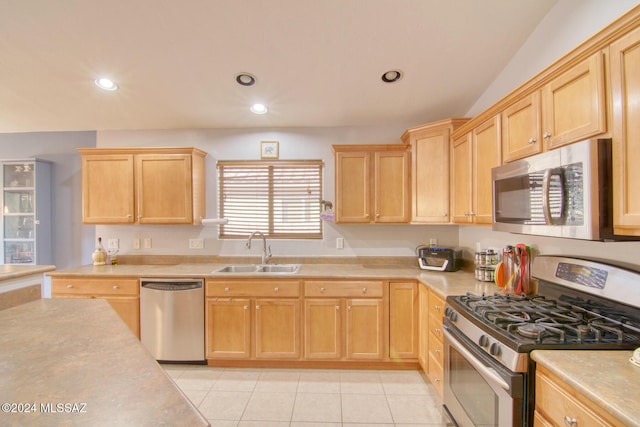 kitchen featuring sink, light tile patterned floors, stainless steel appliances, and light brown cabinetry