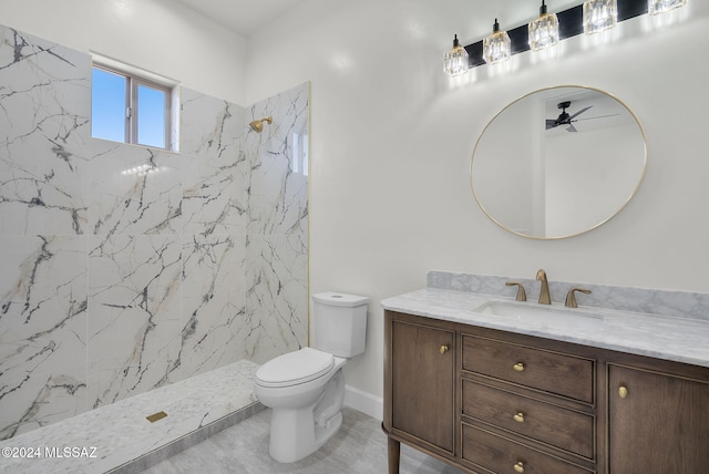 bathroom featuring vanity, tile patterned floors, ceiling fan, toilet, and a tile shower