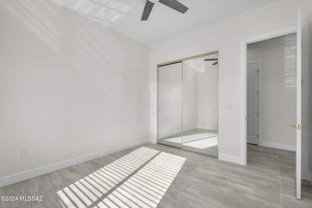 unfurnished bedroom featuring ceiling fan and a closet