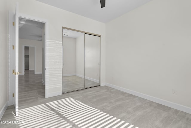 unfurnished bedroom featuring ceiling fan and a closet