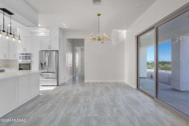 kitchen with pendant lighting, a notable chandelier, white cabinetry, and appliances with stainless steel finishes