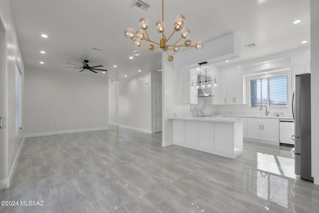 kitchen with white cabinetry, sink, stainless steel fridge, decorative light fixtures, and ceiling fan with notable chandelier