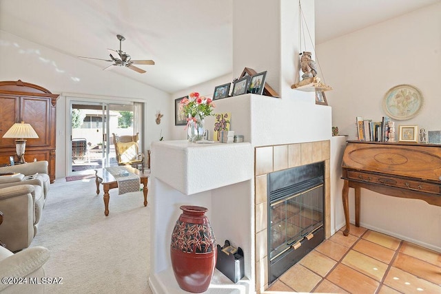 carpeted living room with a fireplace, vaulted ceiling, and ceiling fan