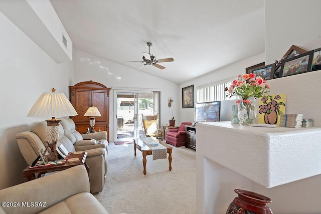 carpeted living room with ceiling fan and vaulted ceiling