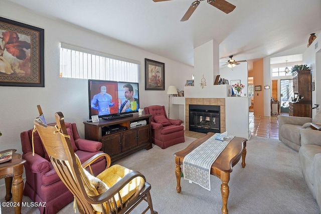 living room featuring ceiling fan, light colored carpet, a fireplace, and vaulted ceiling