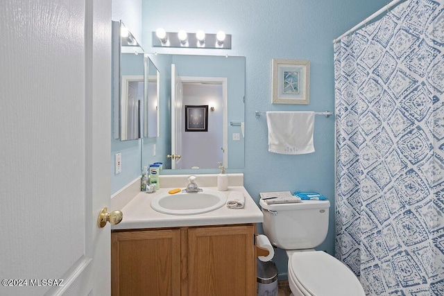 bathroom with vanity, toilet, and walk in shower