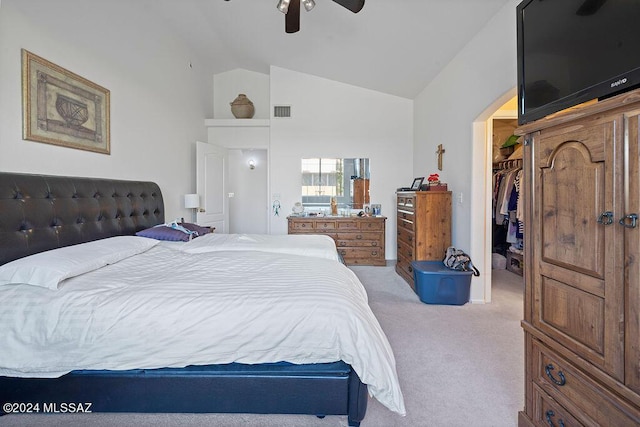 carpeted bedroom with a walk in closet, a closet, lofted ceiling, and ceiling fan