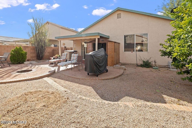 rear view of house with a patio area and an outdoor fire pit