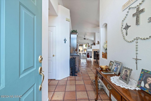 tiled entrance foyer featuring ceiling fan, lofted ceiling, and a tile fireplace