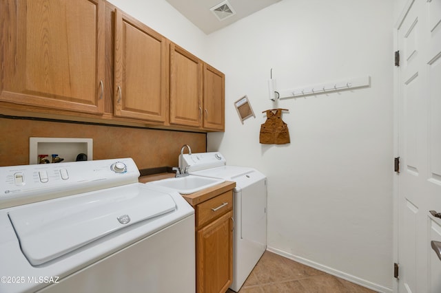 laundry room featuring cabinets, independent washer and dryer, and light tile patterned flooring