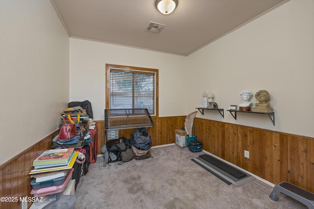 exercise room featuring crown molding, light colored carpet, and wood walls