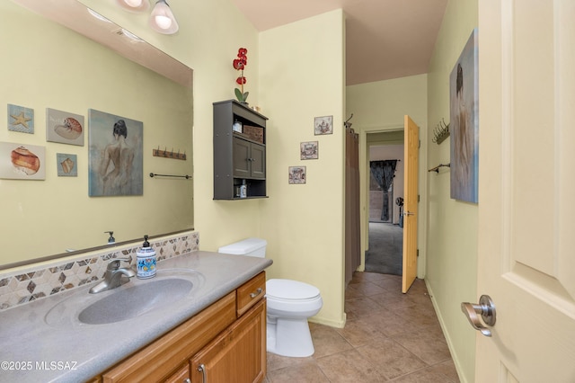 bathroom featuring vanity, tile patterned floors, and toilet