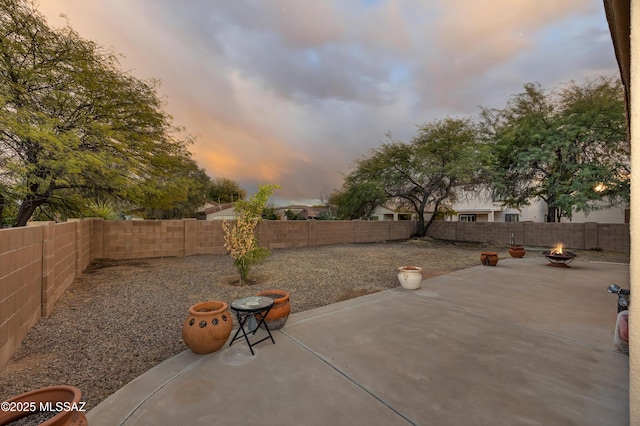 patio terrace at dusk featuring an outdoor fire pit