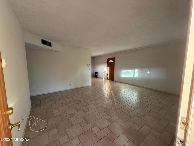 unfurnished room featuring a textured ceiling