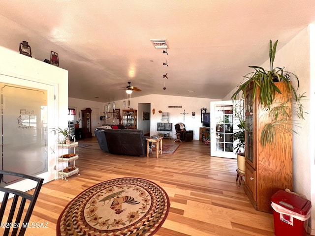 living room with vaulted ceiling, light hardwood / wood-style flooring, and ceiling fan