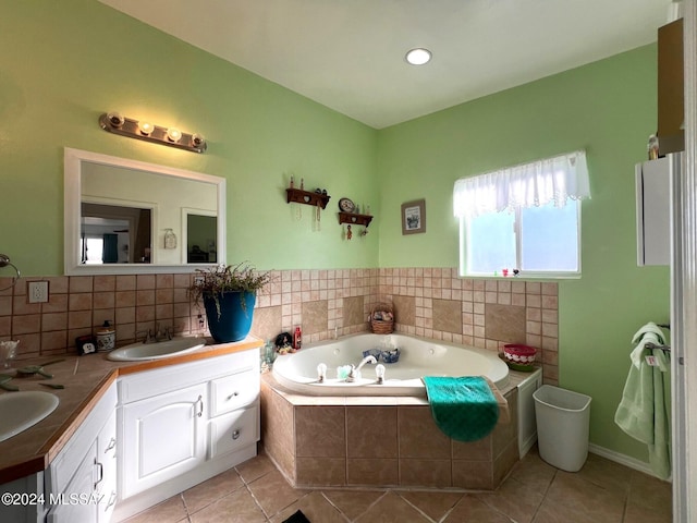 bathroom featuring tile patterned flooring, vanity, and tiled bath