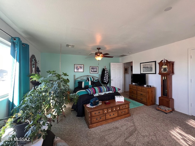 carpeted living room featuring ceiling fan and a textured ceiling