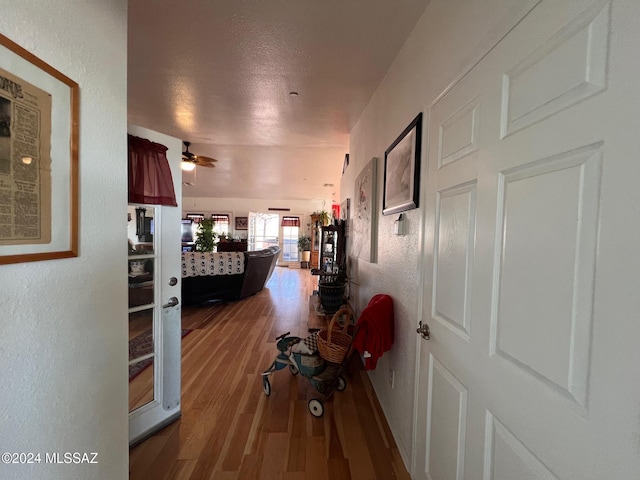 corridor featuring hardwood / wood-style floors and a textured ceiling