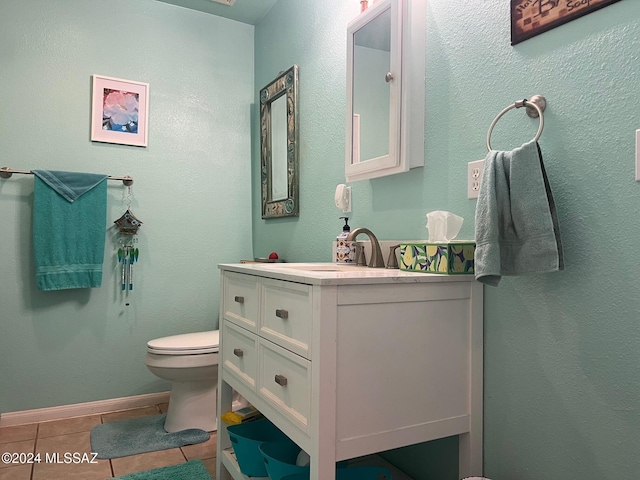 bathroom with tile patterned flooring, vanity, and toilet