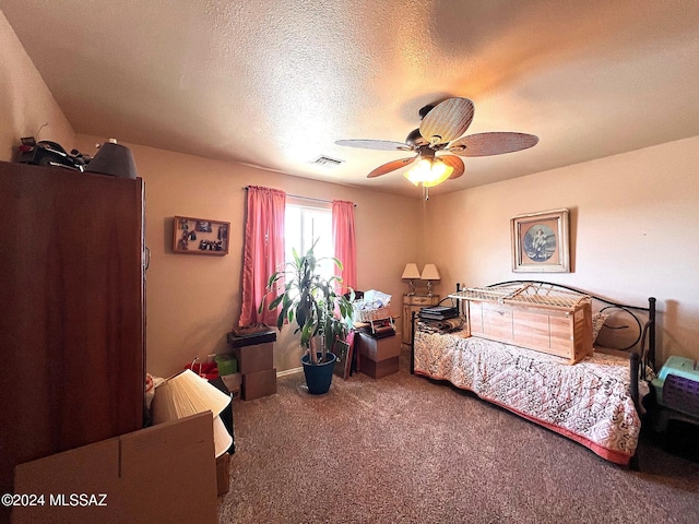 carpeted bedroom featuring ceiling fan, refrigerator, and a textured ceiling