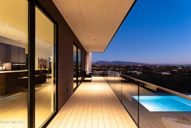 balcony at dusk featuring a mountain view