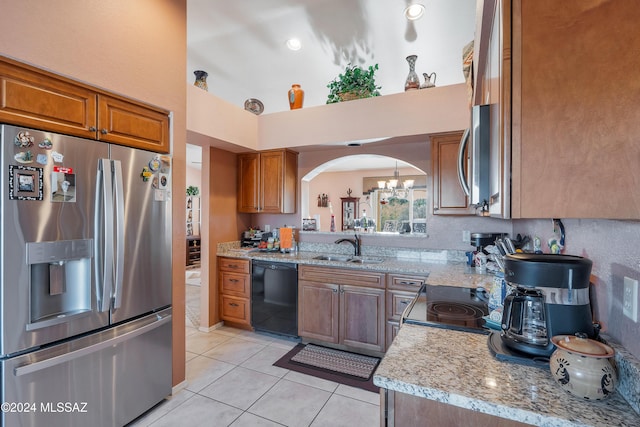 kitchen featuring sink, light stone countertops, stainless steel appliances, and light tile patterned floors