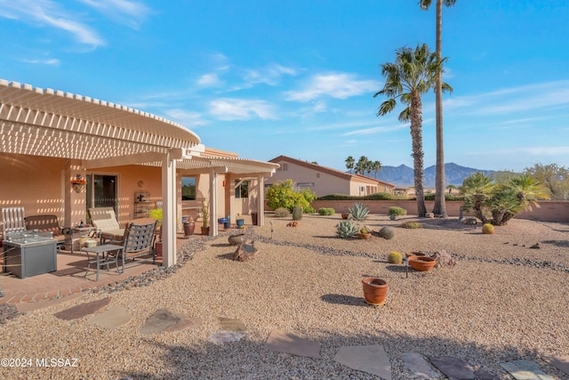 exterior space with a mountain view, a pergola, and a patio area