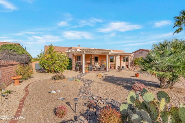 rear view of house featuring a pergola and a patio