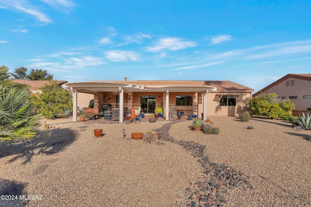 rear view of house featuring a pergola and a patio area