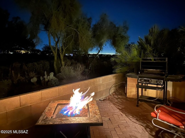 patio at twilight featuring an outdoor fire pit