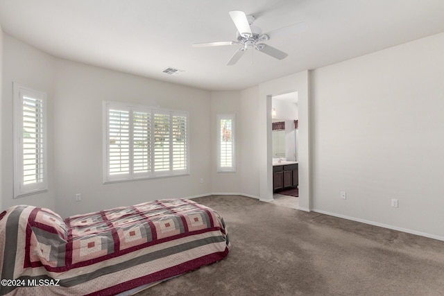 carpeted bedroom featuring connected bathroom, ceiling fan, and multiple windows