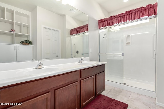 bathroom with tile patterned floors, vanity, and a shower with shower door