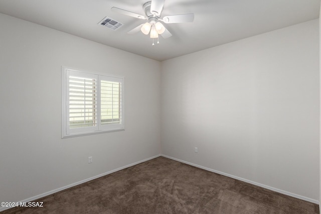 spare room with dark carpet and ceiling fan