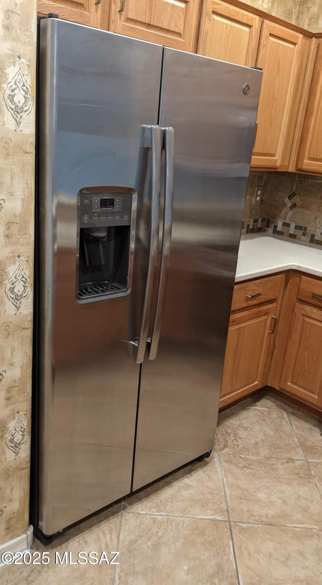 kitchen featuring backsplash and stainless steel refrigerator with ice dispenser