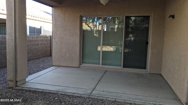 entrance to property with ceiling fan and a patio