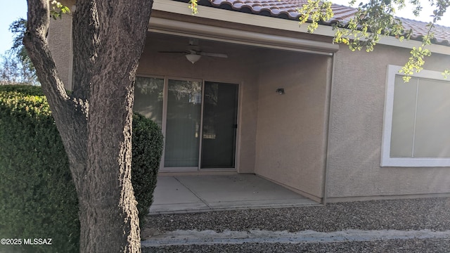 doorway to property with ceiling fan and a patio