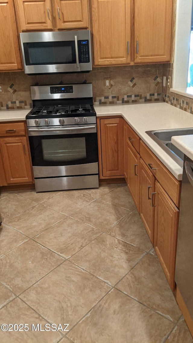 kitchen featuring stainless steel appliances and tasteful backsplash