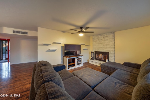 living room with dark hardwood / wood-style floors, ceiling fan, and a fireplace