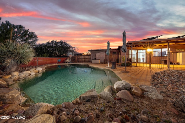 pool at dusk featuring a patio