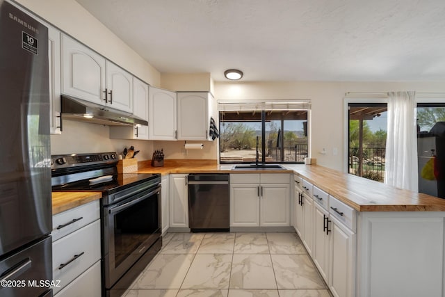 kitchen with stainless steel appliances, a peninsula, marble finish floor, under cabinet range hood, and wooden counters