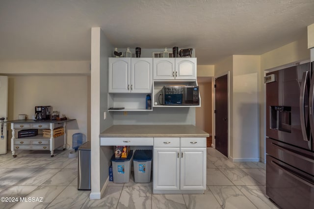 kitchen with white cabinetry, stainless steel fridge with ice dispenser, and a textured ceiling