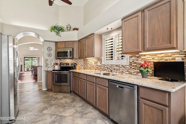 kitchen with ceiling fan, sink, backsplash, and appliances with stainless steel finishes