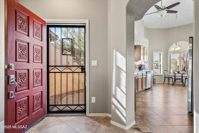 entrance foyer featuring ceiling fan, light tile patterned flooring, and a healthy amount of sunlight