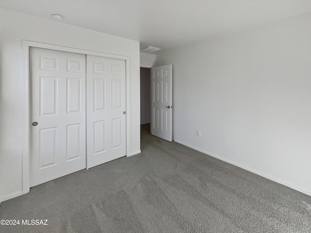 unfurnished bedroom featuring carpet flooring and a closet