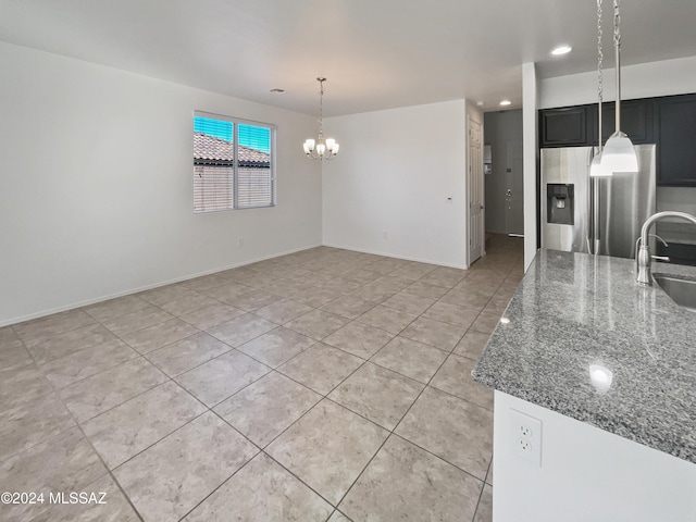 kitchen featuring sink, light tile patterned floors, stone counters, stainless steel fridge with ice dispenser, and a chandelier