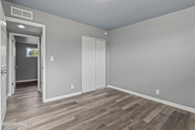 unfurnished bedroom with light hardwood / wood-style flooring and a closet