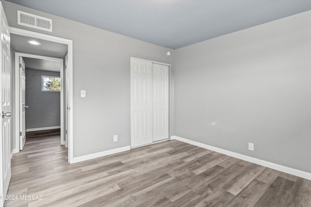 unfurnished bedroom featuring light hardwood / wood-style floors and a closet