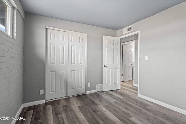 unfurnished bedroom featuring hardwood / wood-style floors and a closet