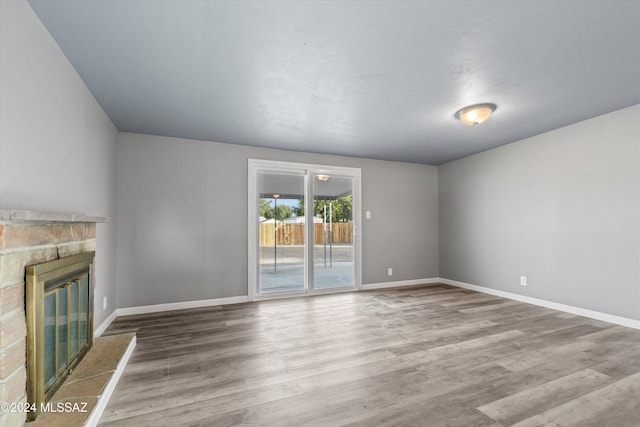 unfurnished living room with wood-type flooring and a fireplace